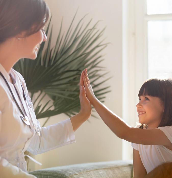 A counselor speaks with a happy girl and her father.